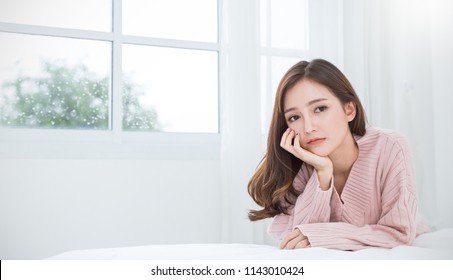 Portrait Of Beautiful Asian Woman Feeling Depress Stress In Bedroom. Sad Face Asian Girl Sit Near Window In Winter. Beauty Treatment Perfect Clear Skin Japanese Korean Makeup  Lifestyle Concept Banner