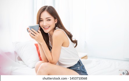 Portrait Of Beautiful Asian Woman Hands Holding Coffee Cup Morning Spring Time In White Bedroom. Happy Cheerful Relaxing In Summer. Korean Makeup Wakeup University, Fresh Coffee In White Cafe Concept