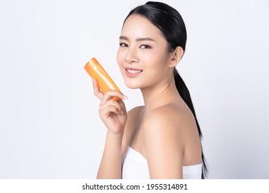 Portrait of beautiful Asian woman holding and presenting cream or or lotion product. Beautiful woman beauty health care, Cosmetology, Wellness and health concept.
