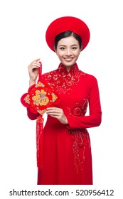 Portrait of a beautiful Asian woman on traditional festival costume Ao Dai holding Hoa Mai tree (Ochna Integerrima) flower. Tet holiday. Lunar New Year.
