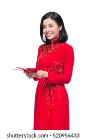 Portrait of a beautiful Asian woman on traditional festival costume Ao Dai holding red pocket - lucky money. Tet holiday. Lunar New Year.