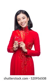 Portrait of a beautiful Asian woman on traditional festival costume Ao Dai holding red pocket - lucky money. Tet holiday. Lunar New Year.