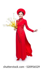 Portrait of a beautiful Asian woman on traditional festival costume Ao Dai holding Hoa Mai tree (Ochna Integerrima) flower. Tet holiday. Lunar New Year.