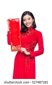 Portrait of a beautiful Asian woman on traditional festival costume Ao Dai showing New Year scrolls Tet holiday. Lunar New Year.