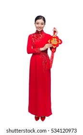Portrait of a beautiful Asian woman on traditional festival costume Ao Dai holding red pocket - lucky money. Tet holiday. Lunar New Year.