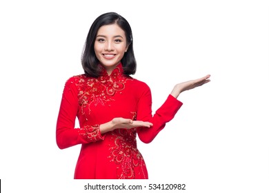 Portrait of a beautiful Asian woman on traditional festival costume Ao Dai holding red pocket - lucky money. Tet holiday. Lunar New Year.