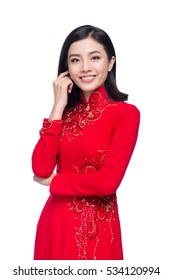 Portrait of a beautiful Asian woman on traditional festival costume Ao Dai holding red pocket - lucky money. Tet holiday. Lunar New Year.