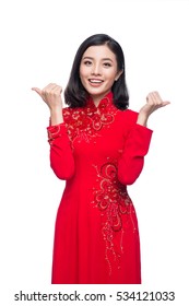 Portrait of a beautiful Asian woman on traditional festival costume Ao Dai holding red pocket - lucky money. Tet holiday. Lunar New Year.