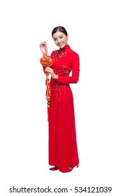 Portrait of a beautiful Asian woman on traditional festival costume Ao Dai holding red pocket - lucky money. Tet holiday. Lunar New Year.