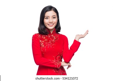 Portrait of a beautiful Asian woman on traditional festival costume Ao Dai holding red pocket - lucky money. Tet holiday. Lunar New Year.