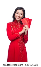 Portrait of a beautiful Asian woman on traditional festival costume Ao Dai holding red pocket - lucky money. Tet holiday. Lunar New Year.