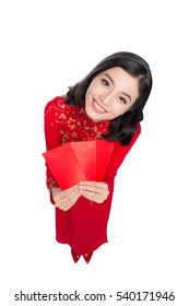 Portrait of a beautiful Asian woman on traditional festival costume Ao Dai holding red pocket - lucky money. Tet holiday. Lunar New Year.