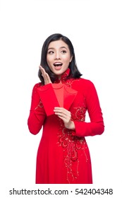 Portrait of a beautiful Asian woman on traditional festival costume Ao Dai holding red pocket - lucky money. Tet holiday. Lunar New Year.