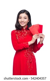 Portrait of a beautiful Asian woman on traditional festival costume Ao Dai holding red pocket - lucky money. Tet holiday. Lunar New Year.