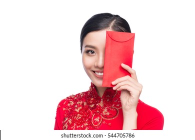 Portrait of a beautiful Asian woman on traditional festival costume Ao Dai holding red pocket - lucky money. Tet holiday. Lunar New Year.