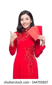 Portrait of a beautiful Asian woman on traditional festival costume Ao Dai holding red pocket - lucky money. Tet holiday. Lunar New Year.