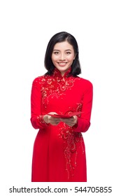 Portrait of a beautiful Asian woman on traditional festival costume Ao Dai holding red pocket - lucky money. Tet holiday. Lunar New Year.