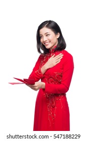Portrait of a beautiful Asian woman on traditional festival costume Ao Dai holding red pocket - lucky money. Tet holiday. Lunar New Year.