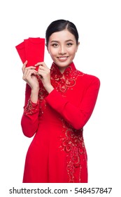 Portrait of a beautiful Asian woman on traditional festival costume Ao Dai holding red pocket - lucky money. Tet holiday. Lunar New Year.