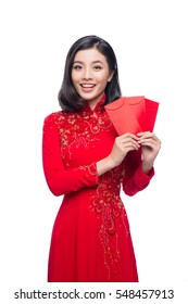 Portrait of a beautiful Asian woman on traditional festival costume Ao Dai holding red pocket - lucky money. Tet holiday. Lunar New Year.