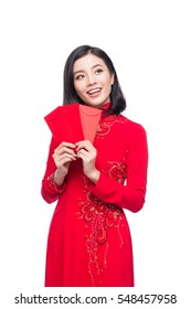 Portrait of a beautiful Asian woman on traditional festival costume Ao Dai holding red pocket - lucky money. Tet holiday. Lunar New Year.