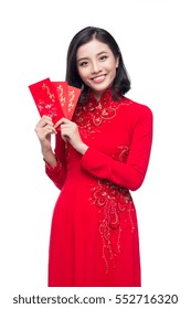 Portrait of a beautiful Asian woman on traditional festival costume Ao Dai holding red pocket - lucky money. Tet holiday. Lunar New Year.
