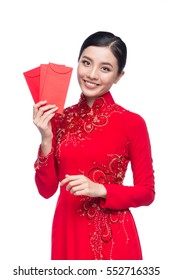 Portrait of a beautiful Asian woman on traditional festival costume Ao Dai holding red pocket - lucky money. Tet holiday. Lunar New Year.