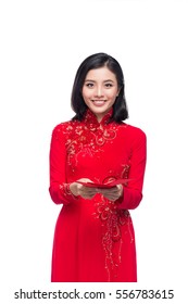 Portrait of a beautiful Asian woman on traditional festival costume Ao Dai holding red pocket - lucky money. Tet holiday. Lunar New Year.