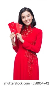 Portrait of a beautiful Asian woman on traditional festival costume Ao Dai holding red pocket - lucky money. Tet holiday. Lunar New Year.