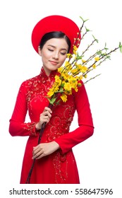 Portrait of a beautiful Asian woman on traditional festival costume Ao Dai holding Hoa Mai tree (Ochna Integerrima) flower. Tet holiday. Lunar New Year.