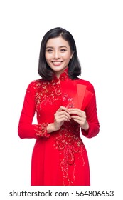 Portrait of a beautiful Asian woman on traditional festival costume Ao Dai holding red pocket - lucky money. Tet holiday. Lunar New Year.