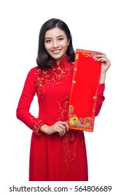 Portrait of a beautiful Asian woman on traditional festival costume Ao Dai holding red pocket - lucky money. Tet holiday. Lunar New Year.