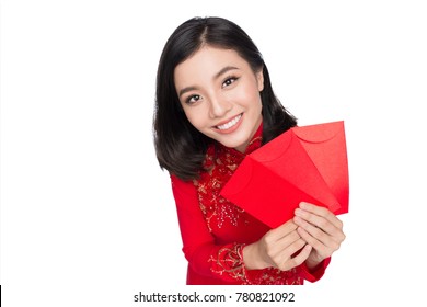 Portrait of a beautiful Asian woman on traditional festival costume Ao Dai holding red pocket - lucky money. Tet holiday. Lunar New Year.
