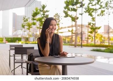 Portrait Of Beautiful Asian Woman Sitting Outdoors At Coffee Shop Restaurant During Summer