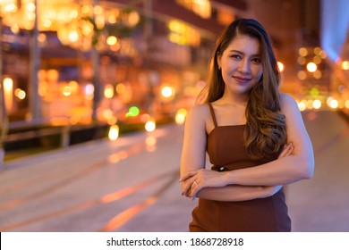 Portrait of beautiful Asian woman smiling outdoors in Bangkok, Thailand at night - Shutterstock ID 1868728918