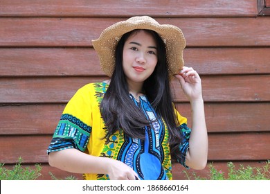 Portrait beautiful Asian woman wearing a hat on Thai traditional wooden background