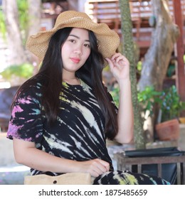 Portrait beautiful Asian woman wearing a hat on Thai traditional wooden background