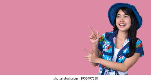 Portrait Of A Beautiful Asian Woman Wearing A Blue Hat And A Hawaiian Shirt With A Pink Background Summer Concept