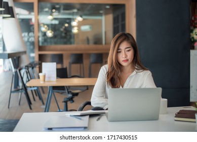 Portrait Of Beautiful Asian Woman Working Financial Report With Laptop Computer At Office.