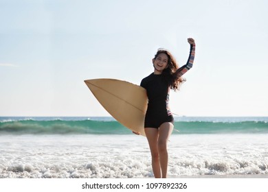 Portrait of beautiful asian young surfer girl with surfboard on a beach. Woman runs into the ocean with surfboard. Sporty people having fun in sunny day - Extreme sport, travel and vacation concept.