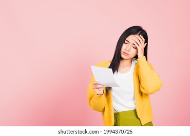 Portrait Of Beautiful Asian Young Woman Sad Tired Strain Holding Paper Calculating Bills On Hand, Female Person Problem She Hold Worried Over Bill, Studio Shot Isolated On Pink Background