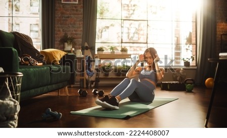 Portrait of a Beautiful Athletic Asian Woman Does ABS Crunches Exercises, Workout, Yoga, Stretching, Training at Home. Sunny Apartment with Positive Smiling Healthy Woman Staying Mindful.