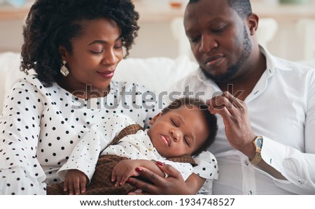 portrait of beautiful baby boy sleeping peacefully in parents hands