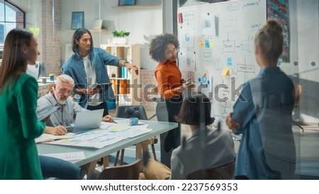 Portrait of a Beautiful Black Woman in Smart Casual Clothes Doing a Presentation in a Meeting Room for her Colleagues. Female Team Lead Explaining Data and Statistics Using a Whiteboard and a Marker