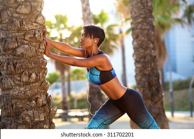 Portrait of a beautiful black woman stretching workout routine