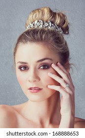 Portrait Of A Beautiful Blond Bride With A Diamante Headpiece. Hair In Romantic Top Knot Bun Hairstyle. 