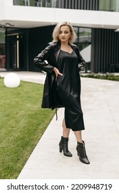 The Portrait Of Beautiful Blond Woman In Black Leather Jacket And Long Dress. Short Hair, Makeup, Style. Everyday Fashion Look. Modern Background.