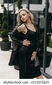 The Portrait Of Beautiful Blond Woman In Black Leather Jacket And Long Dress. Short Hair, Makeup, Style. Everyday Fashion Look. Modern Background.