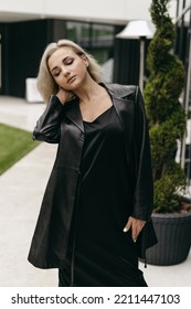 The Portrait Of Beautiful Blond Woman In Black Leather Jacket And Long Dress. Short Hair, Makeup, Style. Everyday Fashion Look. Modern Background.