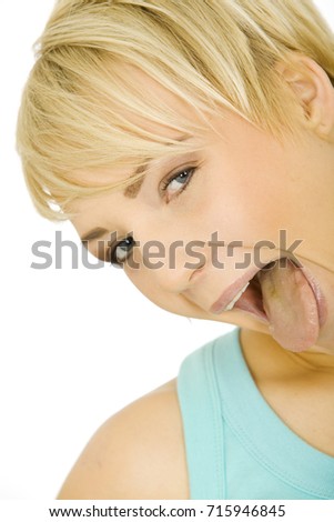 Portrait of a beautiful blond woman sticking her tongue out